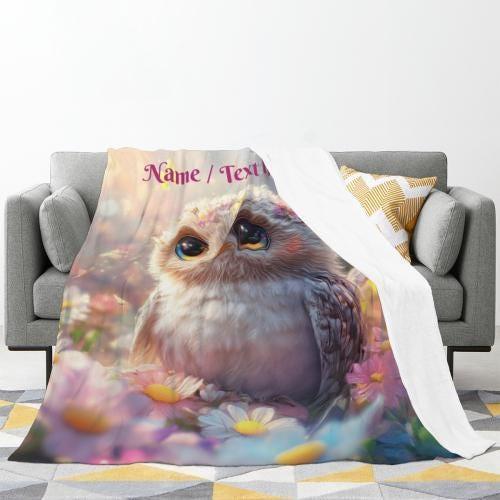 Baby owl fleece blanket draped on couch with custom text and colorful flower print