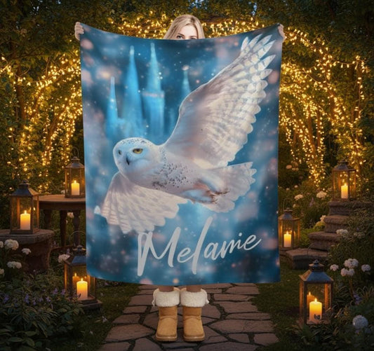 Personalized owl blanket with winged snowy owl artwork and name Melanie on blue background