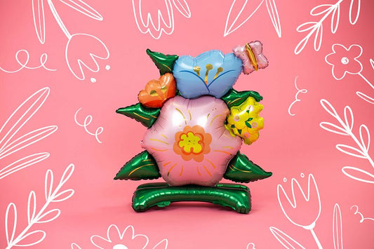 Pastel flower standing balloon with blue top petals, green leaves, orange and yellow accents
