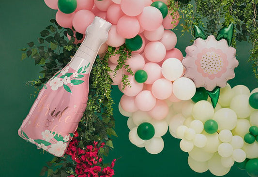 Pastel pink foil flower balloon among pink and green balloon garland