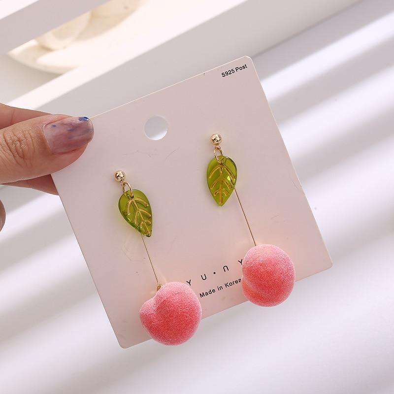 Drop earrings with green leaf charms and pink pom-pom dangles on gold hooks