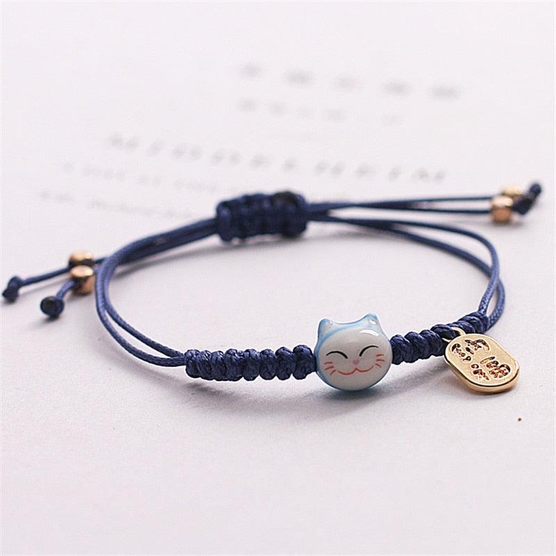 Navy blue cat charm bracelet with light blue cat bead and gold-tone heart tag