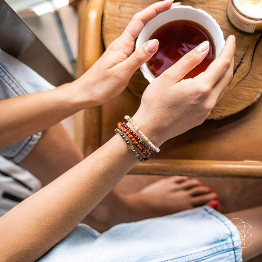 Stacked beaded magnet bracelets on wrist with red, gold and silver bead strands
