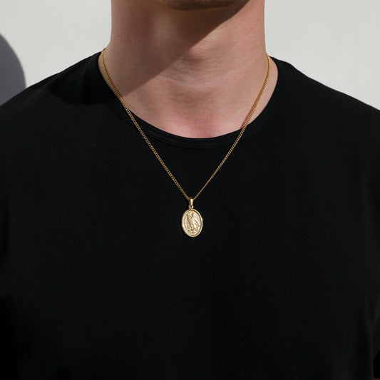 Gold Saint Michael medal necklace on fine chain, oval pendant centered on chest