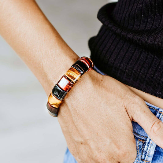 Beaded bracelet on wrist, dark, amber, and red resin beads with silver-toned rings