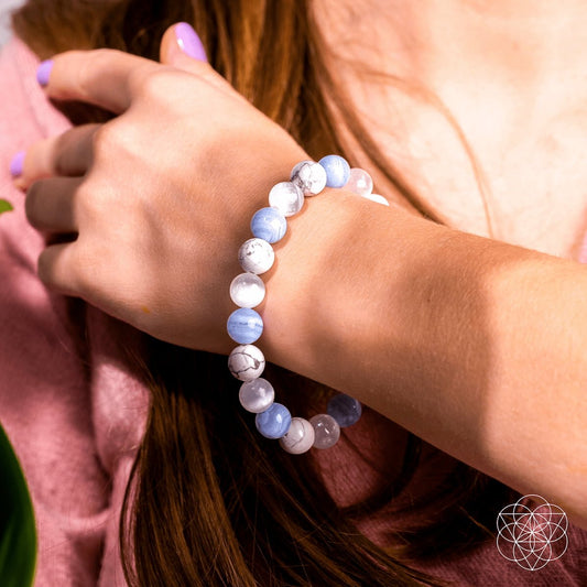 Beaded bracelet worn on wrist, featuring blue and white round beads with silver accents