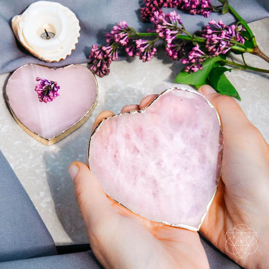 Heart-shaped pink rose quartz coaster with marbled pattern, held in hand