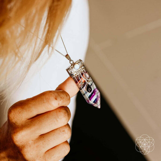 Purple-blue crystal-point necklace pendant on a silver chain with ornate top