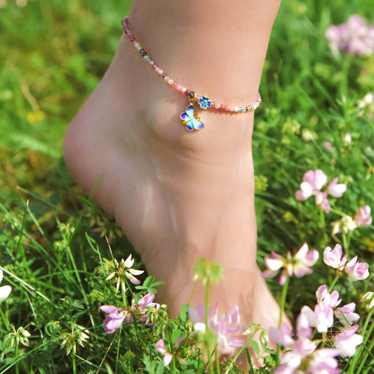 Beaded anklet with multicolor stones and blue flower charm on ankle