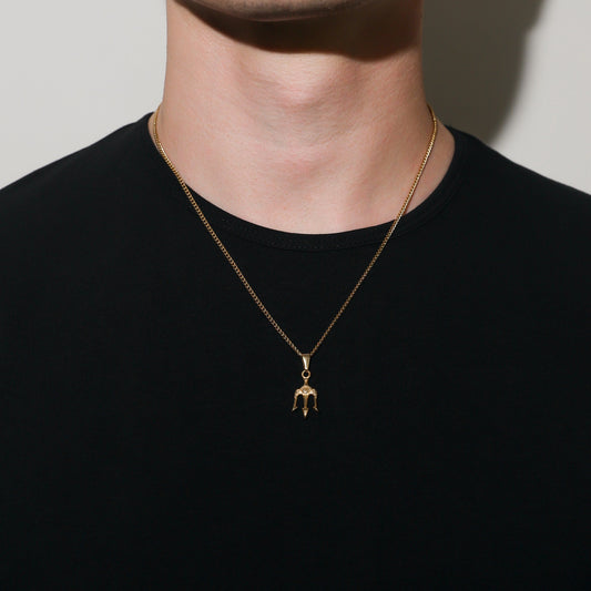 Gold trident pendant necklace on curb chain, worn on neck