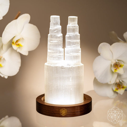 Two-tier selenite lamp with clear glowing selenite columns on a dark wooden base