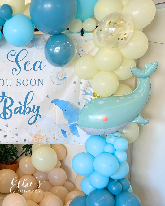 Whale-shaped balloon centerpiece in light blue with a pink dot on its belly