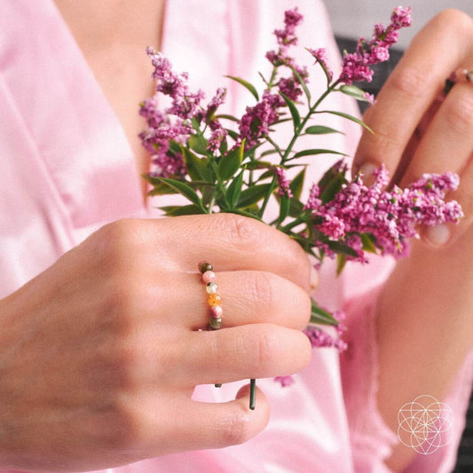 Multicolor beaded rings on finger, showing small round bead stones