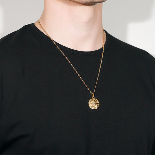 Gold coin pendant on a slim chain necklace, centered at the chest