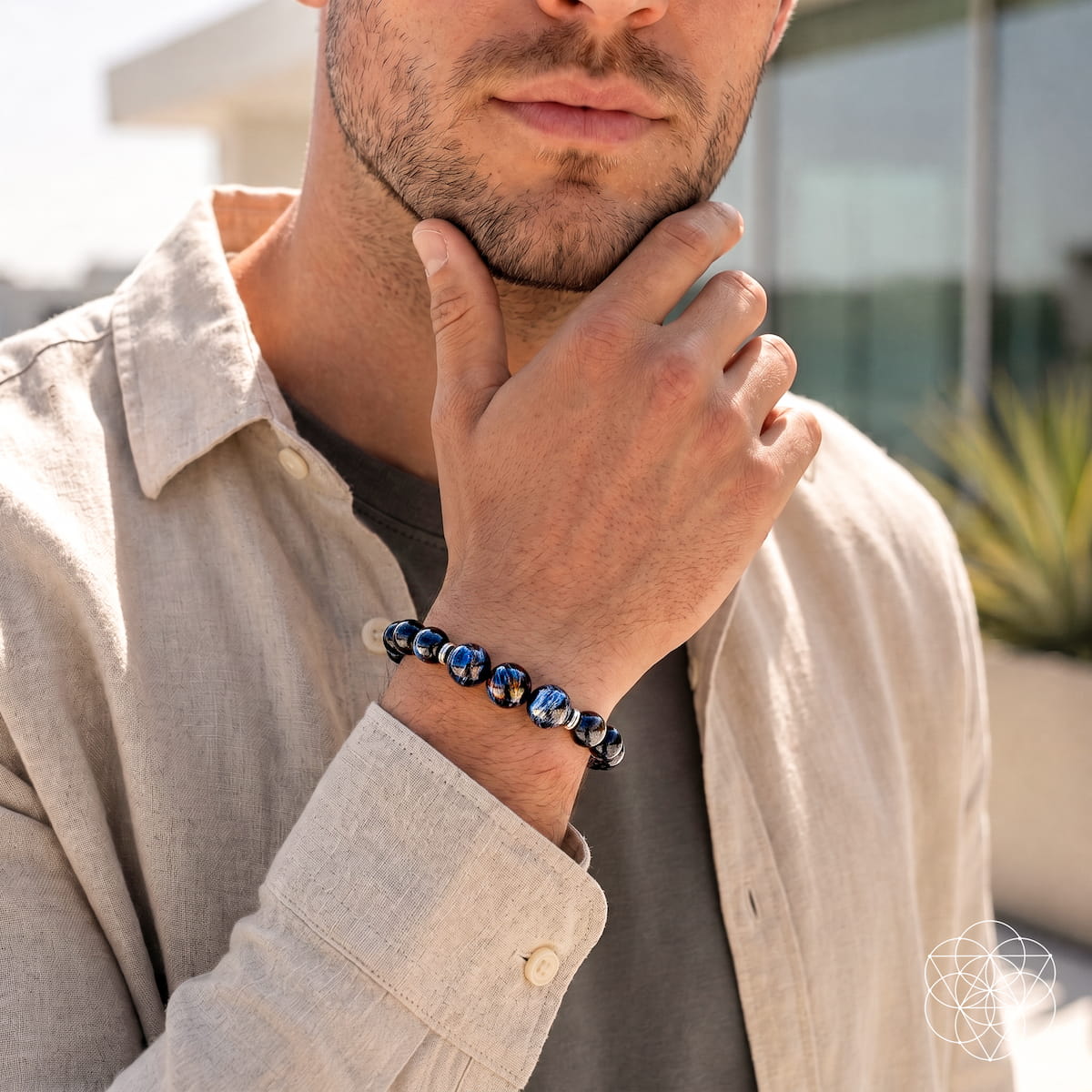 Bracelet worn on arm: dark glossy beads with blue stone accents in a stretch design
