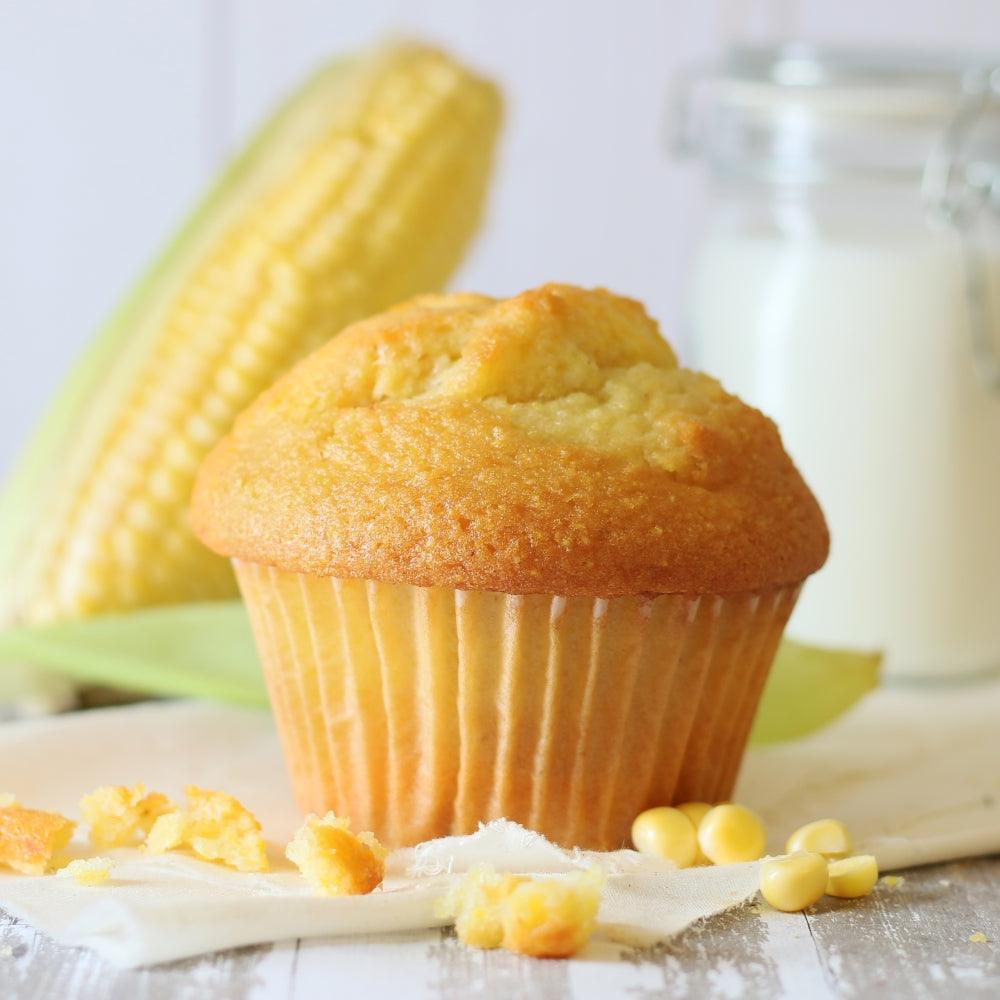 Goldener Muffin mit gebräunter Oberfläche, Krümel und weißem Zuckerguss