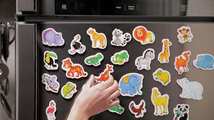 Zoo animal fridge magnets arranged on a metal refrigerator door