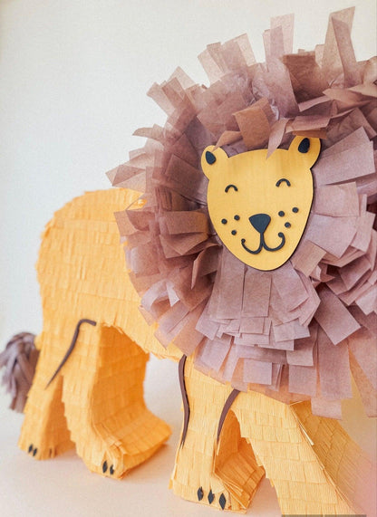 Piñata de león con melena morada y patas de papel, primer plano