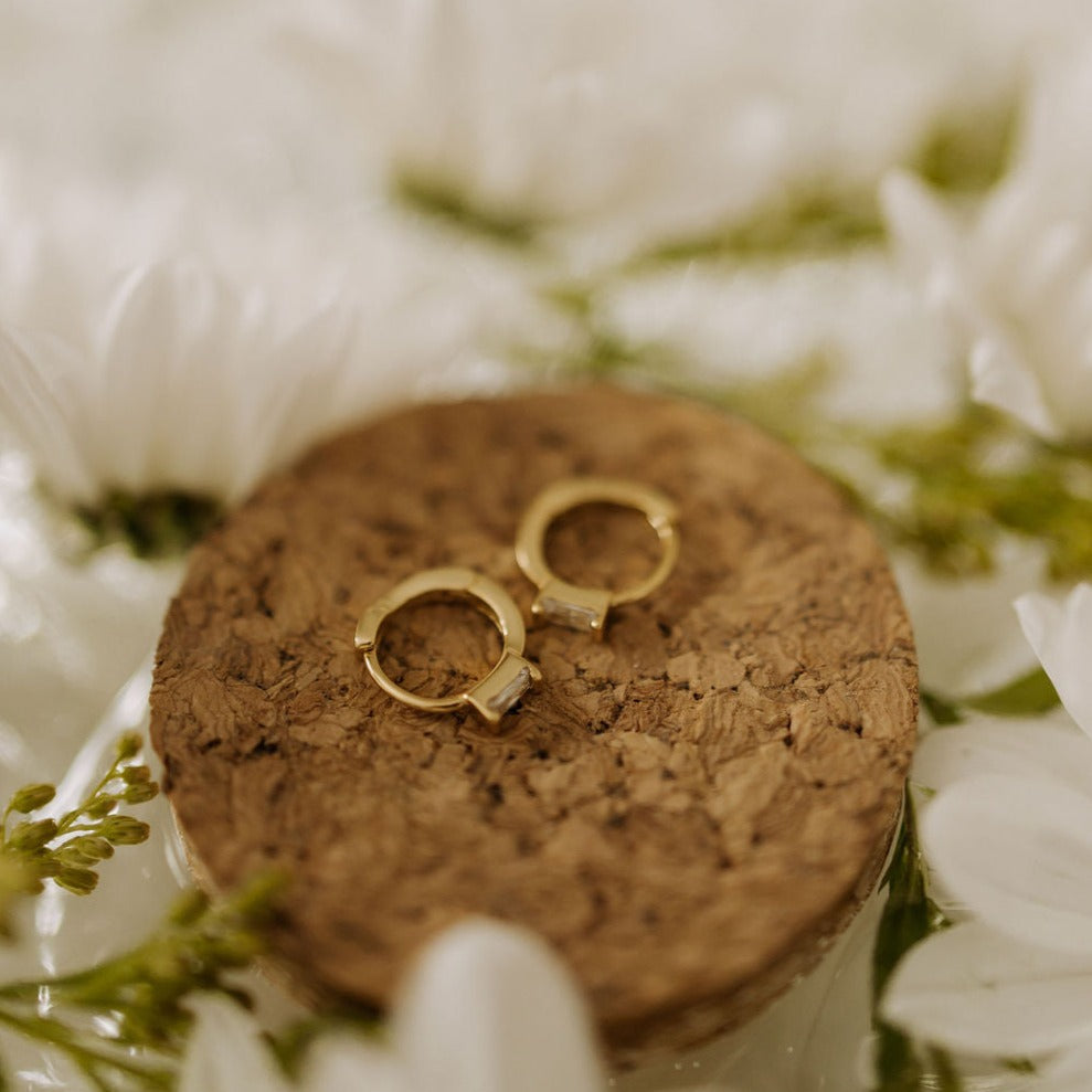 Pair of gold mini hoop earrings with rectangular baguette stones