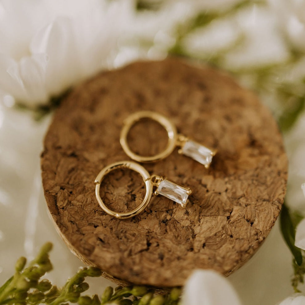 Pair of gold hoops with dangling clear rectangular stones