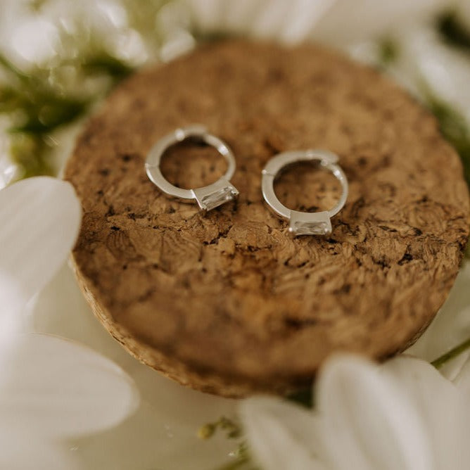 Close-up of silver mini hoop earrings with baguette stones