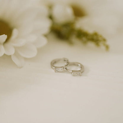 Silver baguette diamond mini hoop earrings, shown as a pair