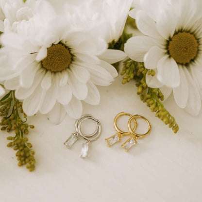 Gold and silver hoop earrings with clear baguette-cut drops