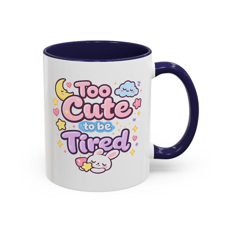 White mug with navy rim and handle, kawaii bunny “Too Cute to be Tired” design front view.