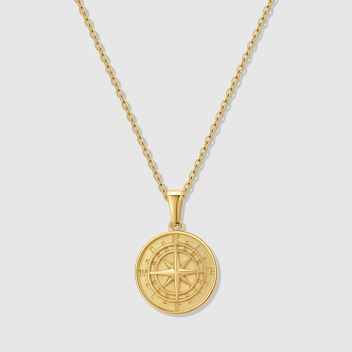 Gold compass pendant necklace with round medallion and compass rose on chain