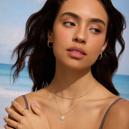 Gold satellite-style choker necklace with a small round pendant at center