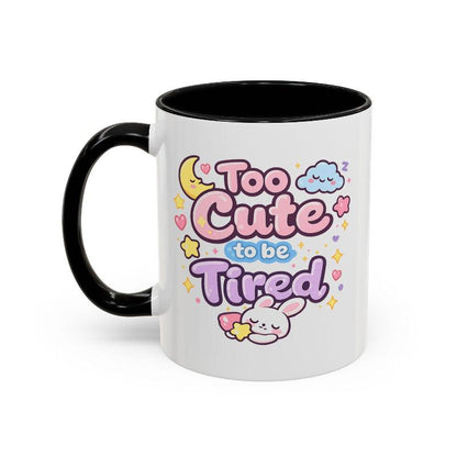 White mug with black rim and handle, kawaii bunny “Too Cute to be Tired” graphic.