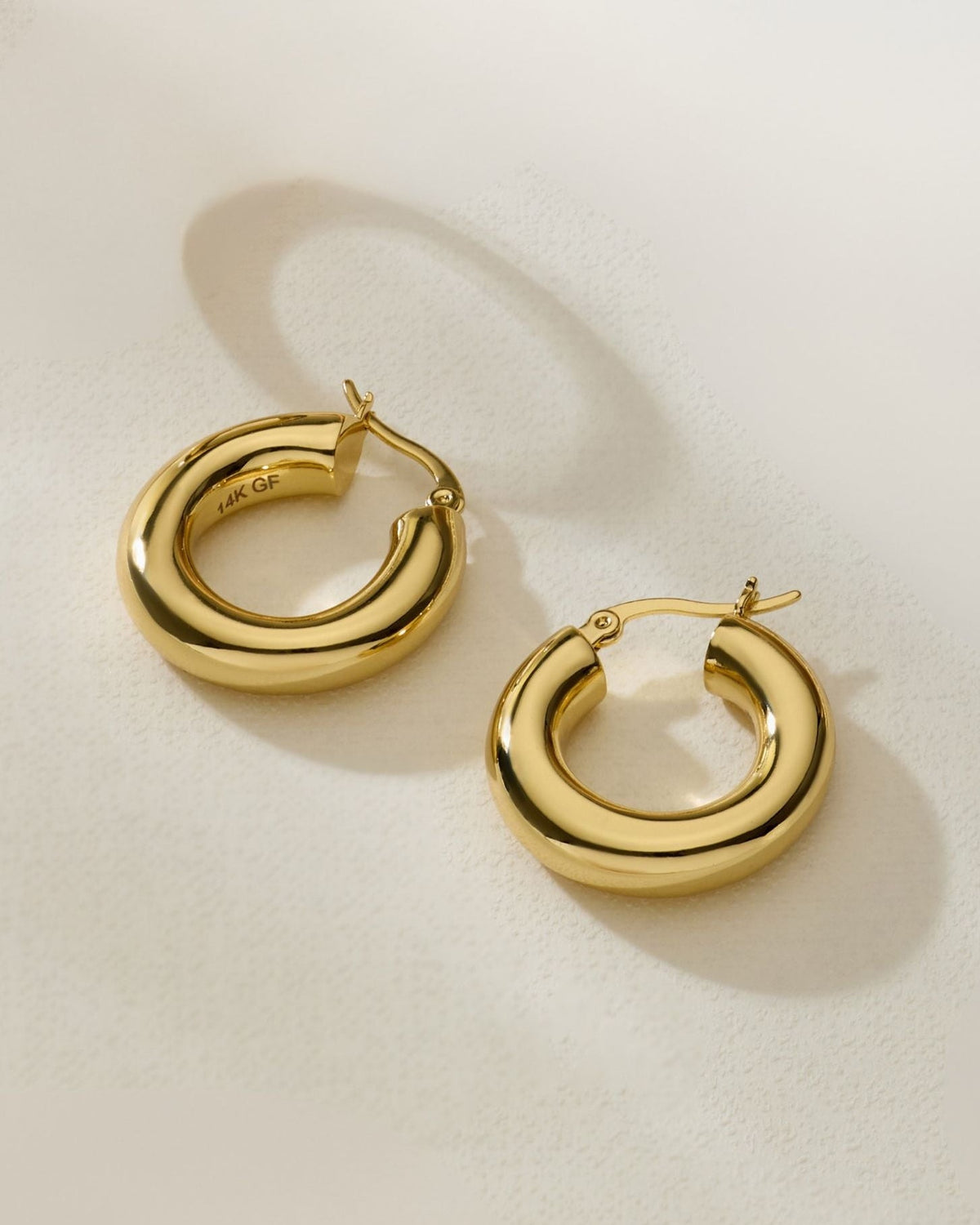 Gold chunky hoop earrings with rounded sculpted profile