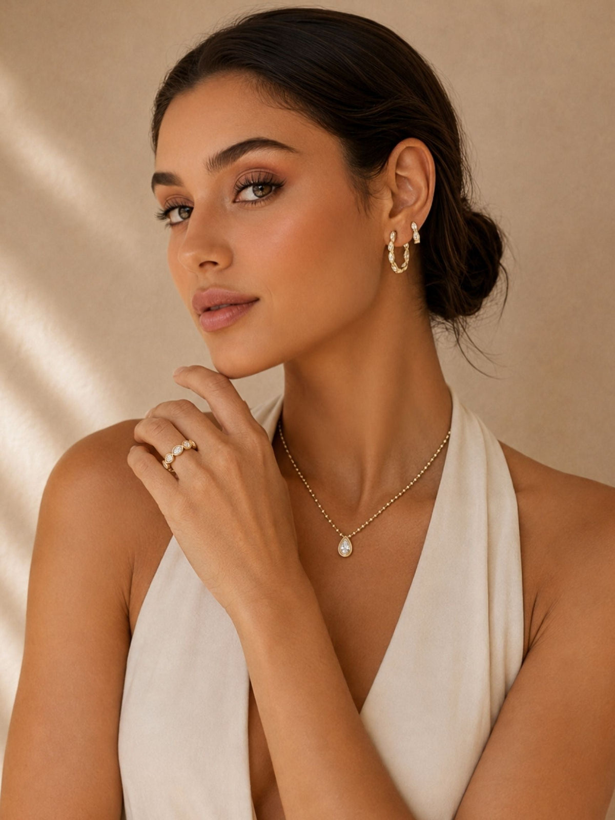 Gold ball-link necklace with teardrop pendant, model wearing white halter top