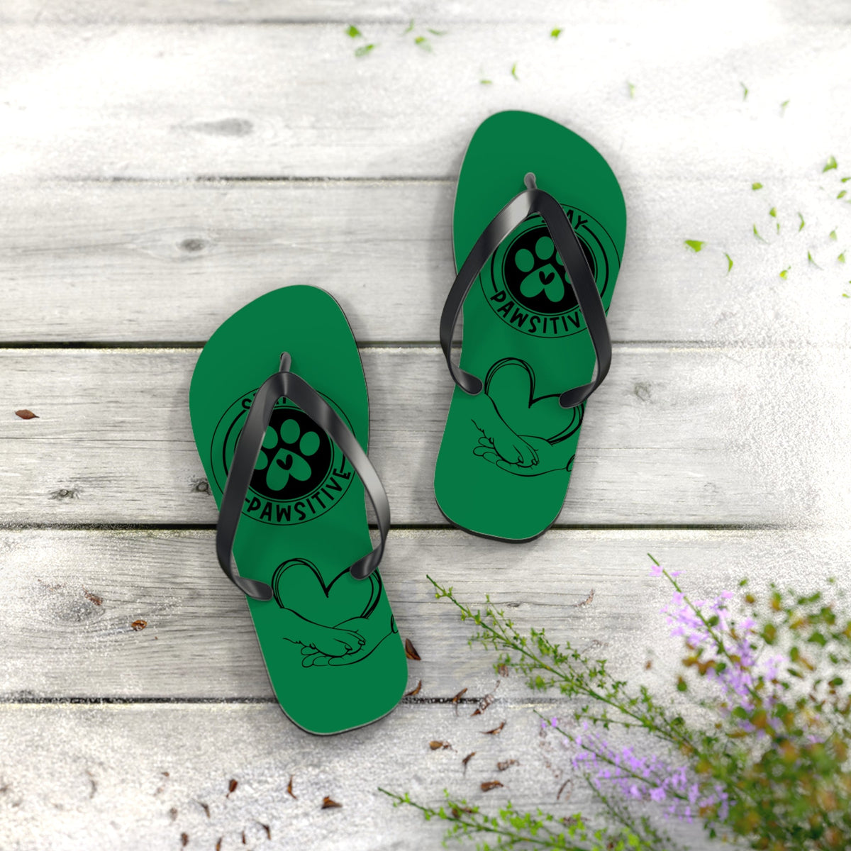 Green flip-flops with black toe straps and paw-print graphic on footbed