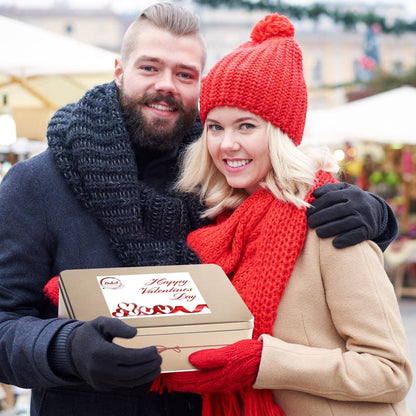 Gourmet cookie and brownie tin held by a couple for gift delivery