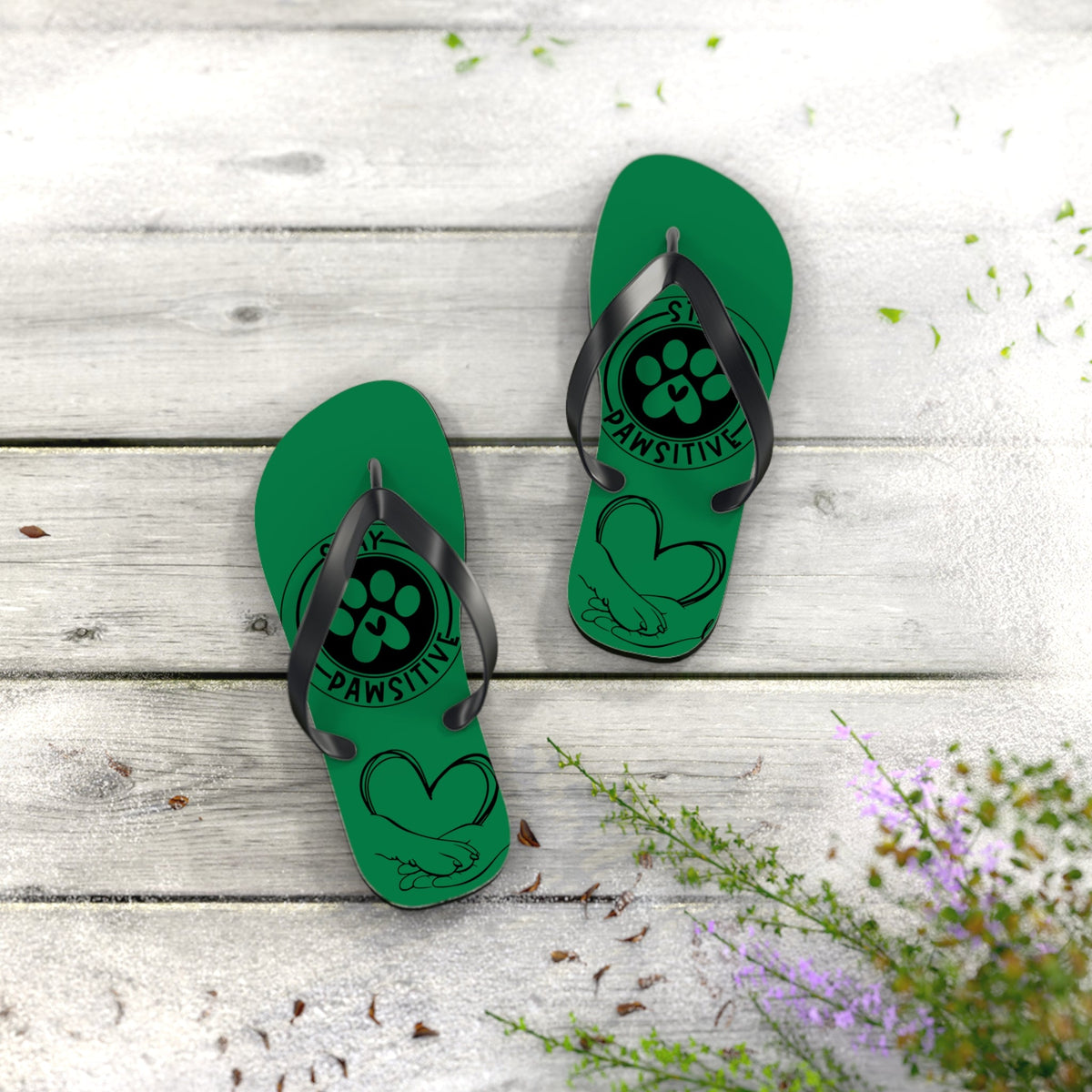 Green flip-flops with black straps and paw-print “PAWSITIVE” graphic on front