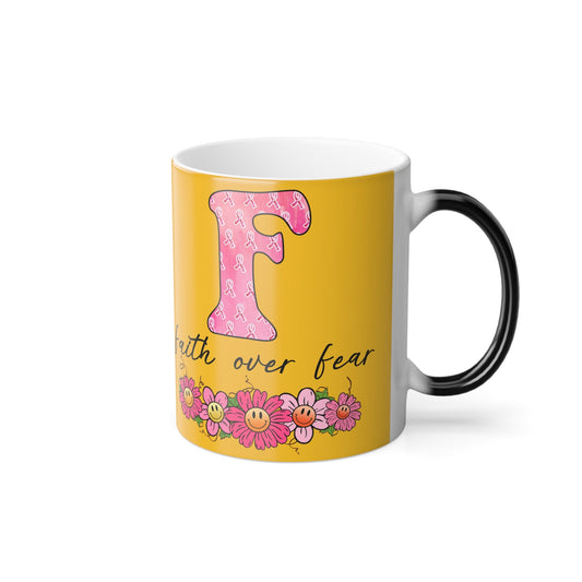 11oz color-morphing mug in yellow with black handle, pink ribbon graphic and “faith over fear”
