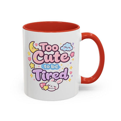 White mug with orange rim and handle, kawaii bunny “Too Cute to be Tired” design front view.