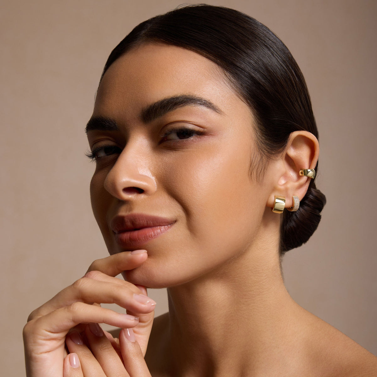 Gold small hoop earrings on model, side view near the ear
