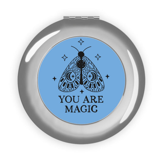 Silver glossy compact travel mirror with blue “You Are Magic” moth design on cover