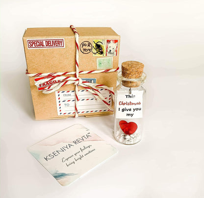 Ribbon-tied kraft gift box with letter card and glass apology message bottle with cork