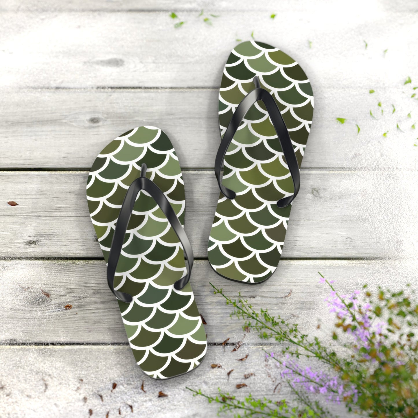 Pair of green scale print flip flops with black thong straps