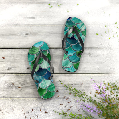 Mermaid-scale flip flops shown from above, black straps with teal and green scales