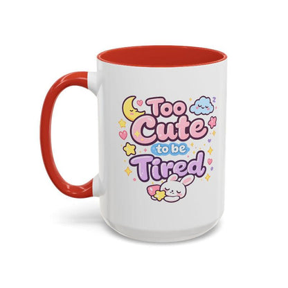 White mug with red rim and handle, “Too Cute to be Tired” bunny graphic.