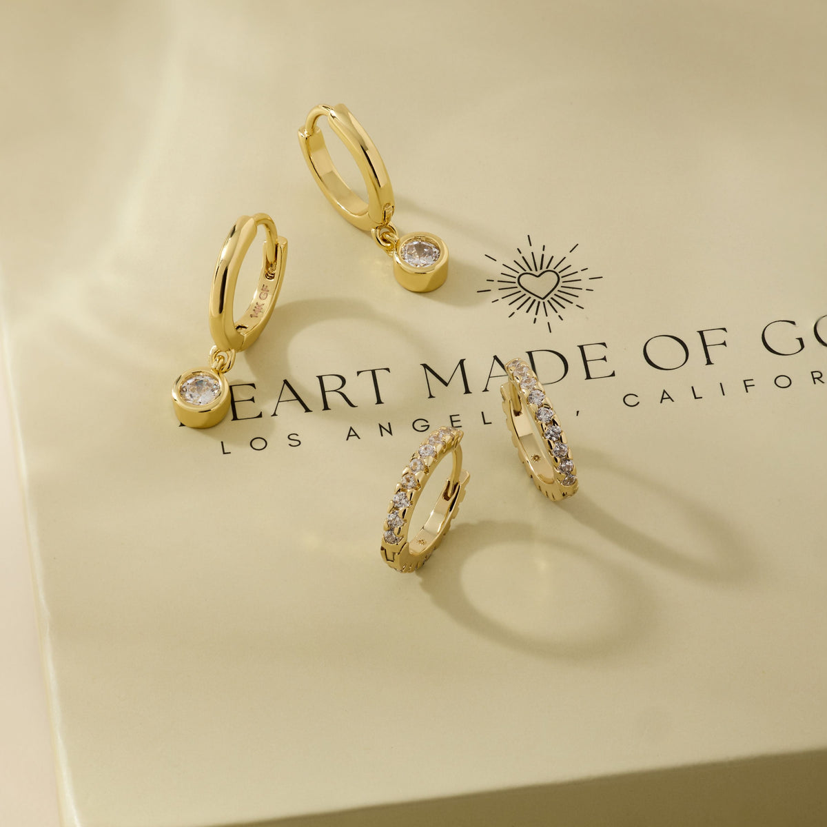 Gold diamond huggie hoop earrings with dangling charm