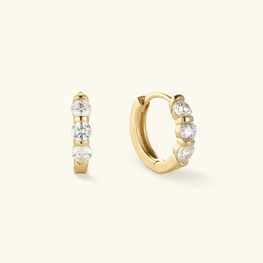 Gold huggie hoop earrings with three round clear stones, pair