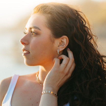 Gold-filled diamond hoops worn with other delicate gold jewelry
