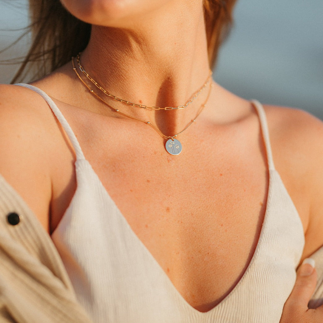 Gold-filled paperclip necklace layered with a round pendant chain.