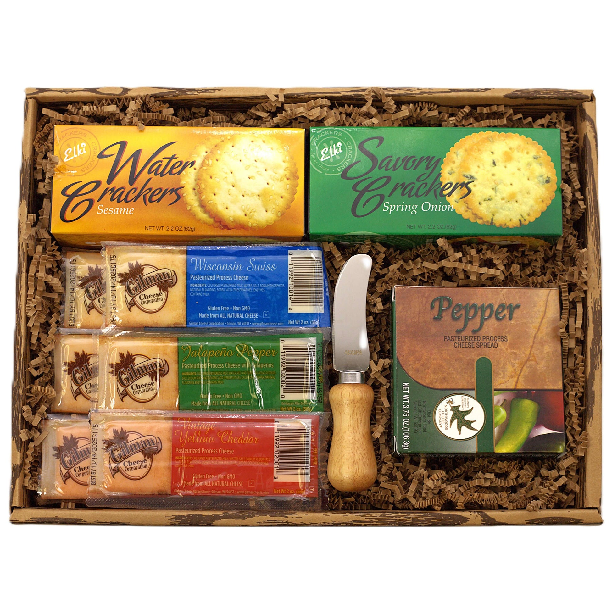 Open cheese gift box with packaged crackers, cheese bars, and a wooden cheese spreader
