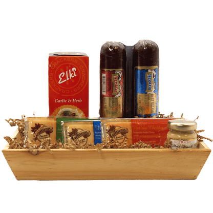 Rustic wooden gift crate with crackers, cheese packages, and salami bottles
